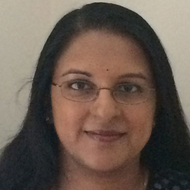 Portrait of Mallika Krishnan smiling at the camera.